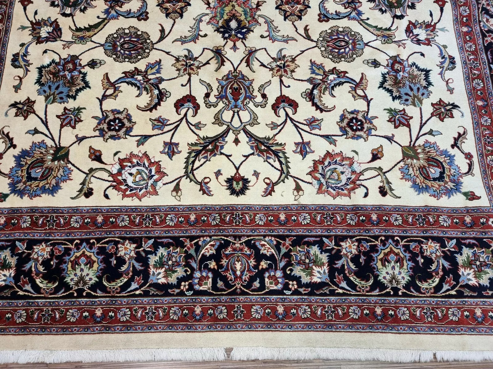 Detail of the scrolling vine and leaf patterns woven throughout the design.

