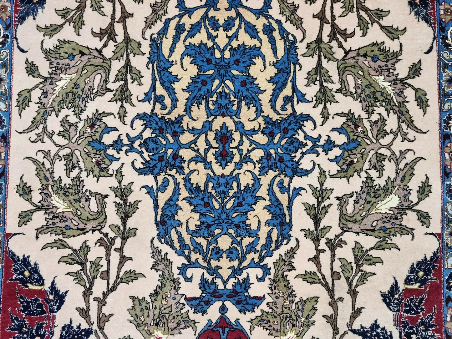 Close-up of the scrolling vine and arabesque motifs in ivory and sky blue.

