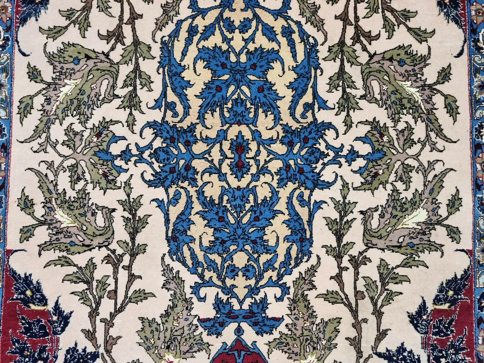 Close-up of the scrolling vine and arabesque motifs in ivory and sky blue.

