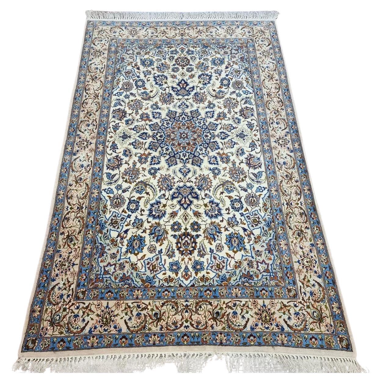 Full view of a vintage Persian Isfahan rug from the 1970s, hand-knotted in kork wool on a silk foundation, featuring a beige color palette and classic intricate floral motifs.

