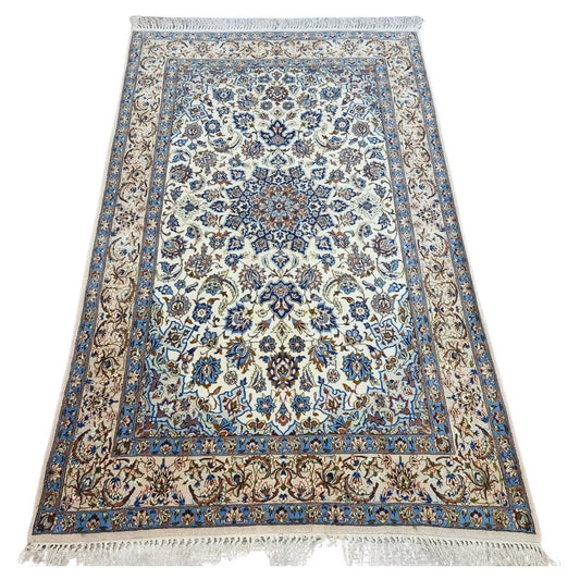 Full view of a vintage Persian Isfahan rug from the 1970s, hand-knotted in kork wool on a silk foundation, featuring a beige color palette and classic intricate floral motifs.

