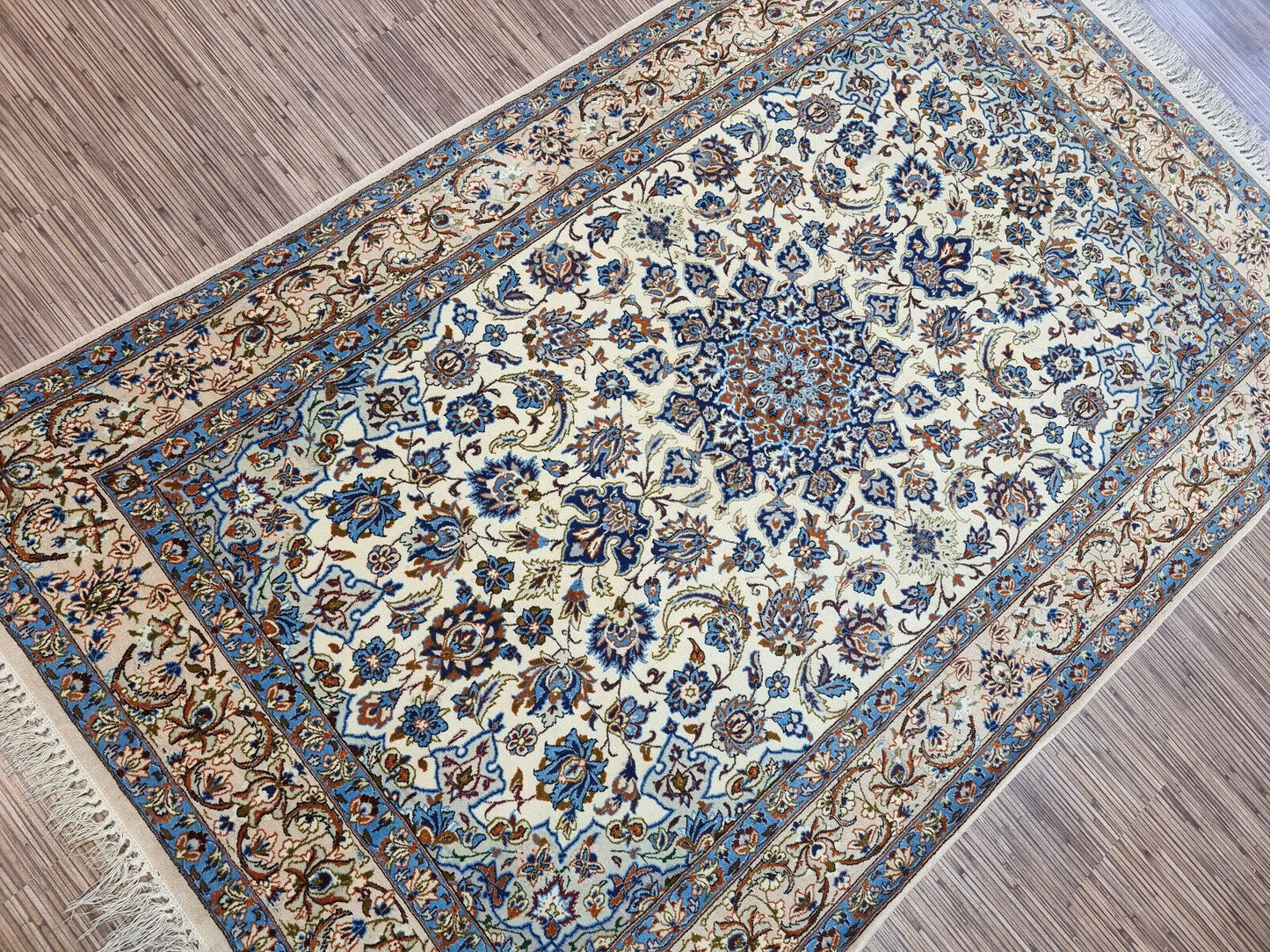 Vintage Isfahan rug measuring 3.6 x 5.6 feet with a rectangular shape, soft beige background, and detailed oriental floral designs typical of 1970s Persian craftsmanship.

