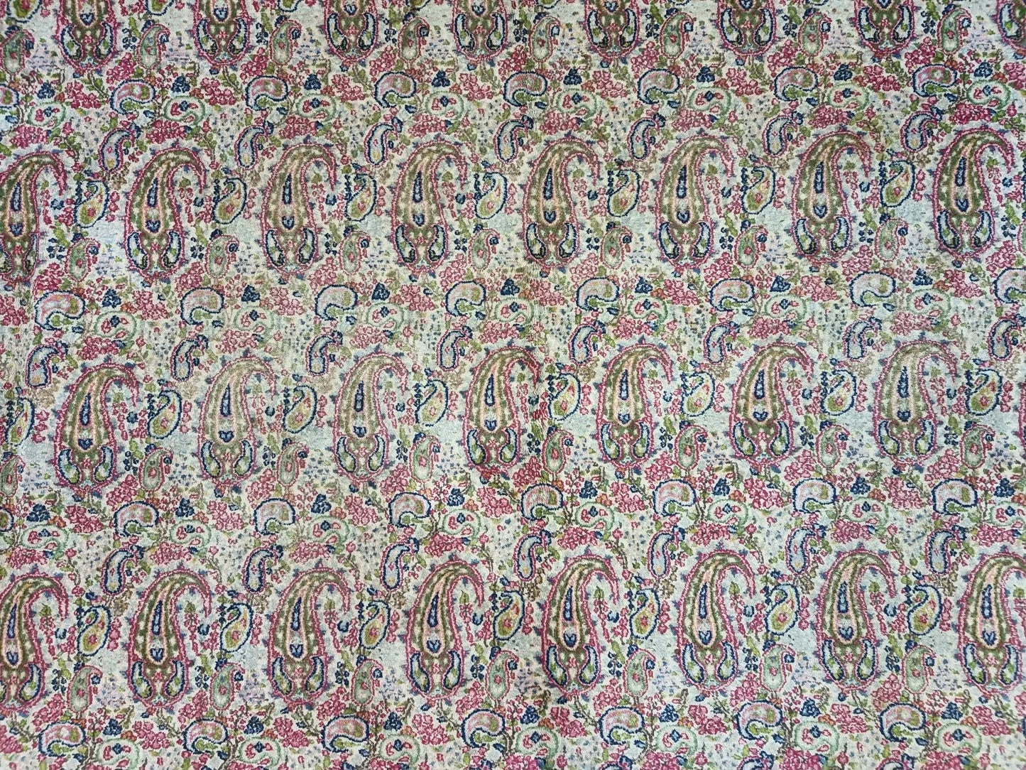 Detail of the central medallion and corner spandrels on a vintage Persian Kerman carpet, showcasing intricate precision and soft beige coloration.

