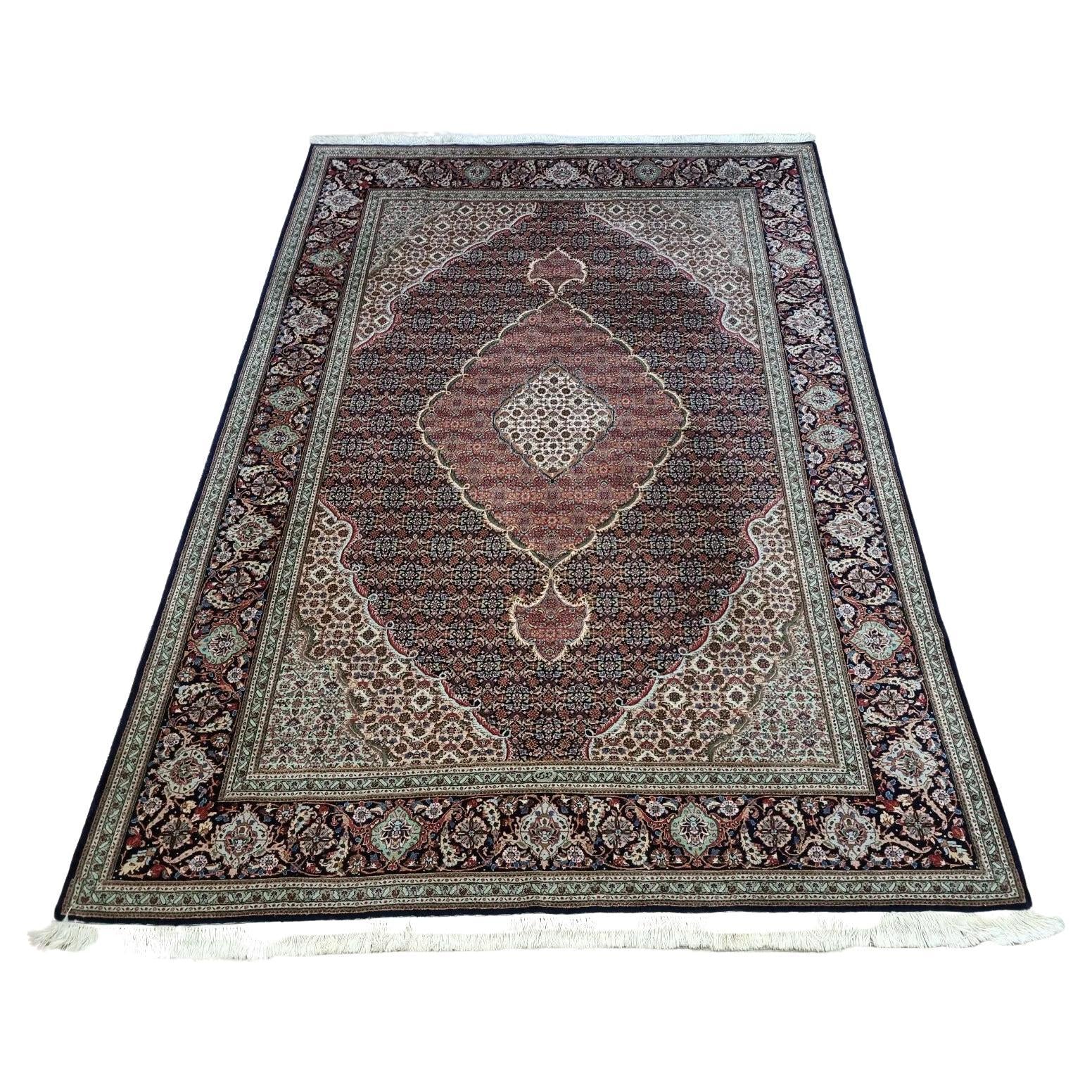 Full view of a handmade vintage Persian Tabriz rug from the 1970s, featuring a detailed floral pattern in rich blue tones, hand-knotted with approximately 500,000 knots per square meter.

