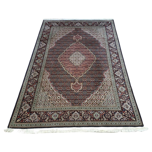 Full view of a handmade vintage Persian Tabriz rug from the 1970s, featuring a detailed floral pattern in rich blue tones, hand-knotted with approximately 500,000 knots per square meter.

