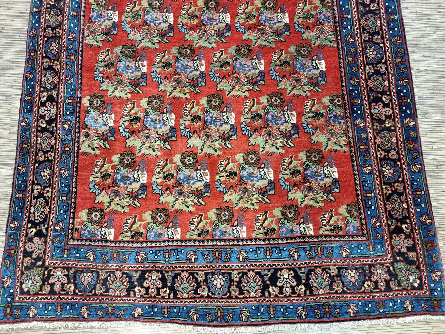 Detail of the central medallion and corner spandrels on an antique Bidjar rug, showcasing the rich floral pattern and dense weave characteristic of Bidjar durability.

