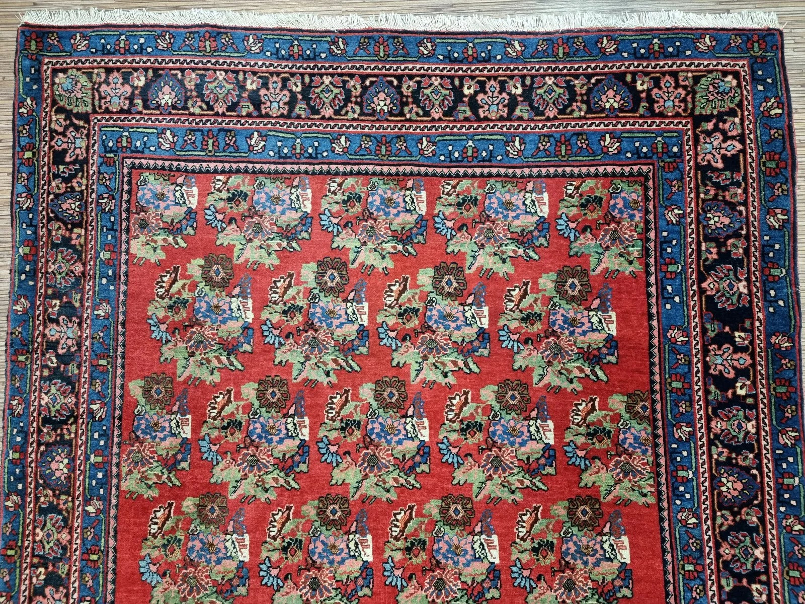 Full perspective of an antique Persian Bidjar rug displayed in an interior setting, demonstrating its versatility for living rooms, dining areas, or as a decorative focal point.

