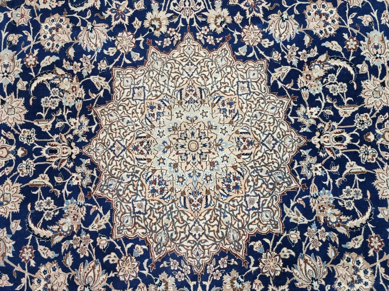 Detail of the central medallion and corner spandrels on a vintage Nain 6La Tudeshk rug, showcasing the refined detailing and high knot density that ensures precision in design.

