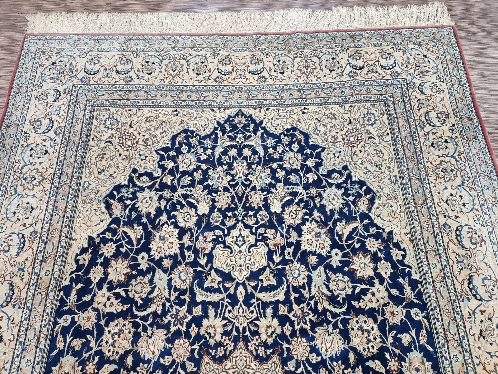 Full perspective of an antique Persian Nain rug displayed in a room setting, demonstrating its 7.1 × 11.5 foot size as a luxurious centerpiece for traditional or contemporary interiors.


