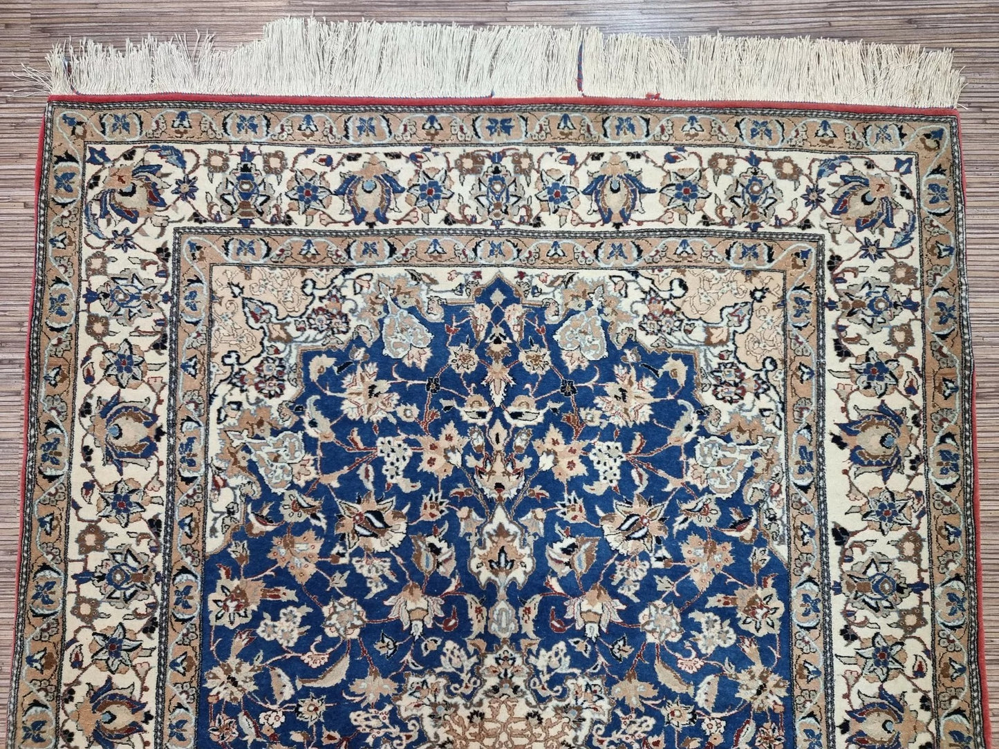 Full perspective of an antique Persian Nain rug displayed in a room setting, demonstrating its 3.9 × 5.4 foot size as a refined accent piece for traditional or modern interiors.

