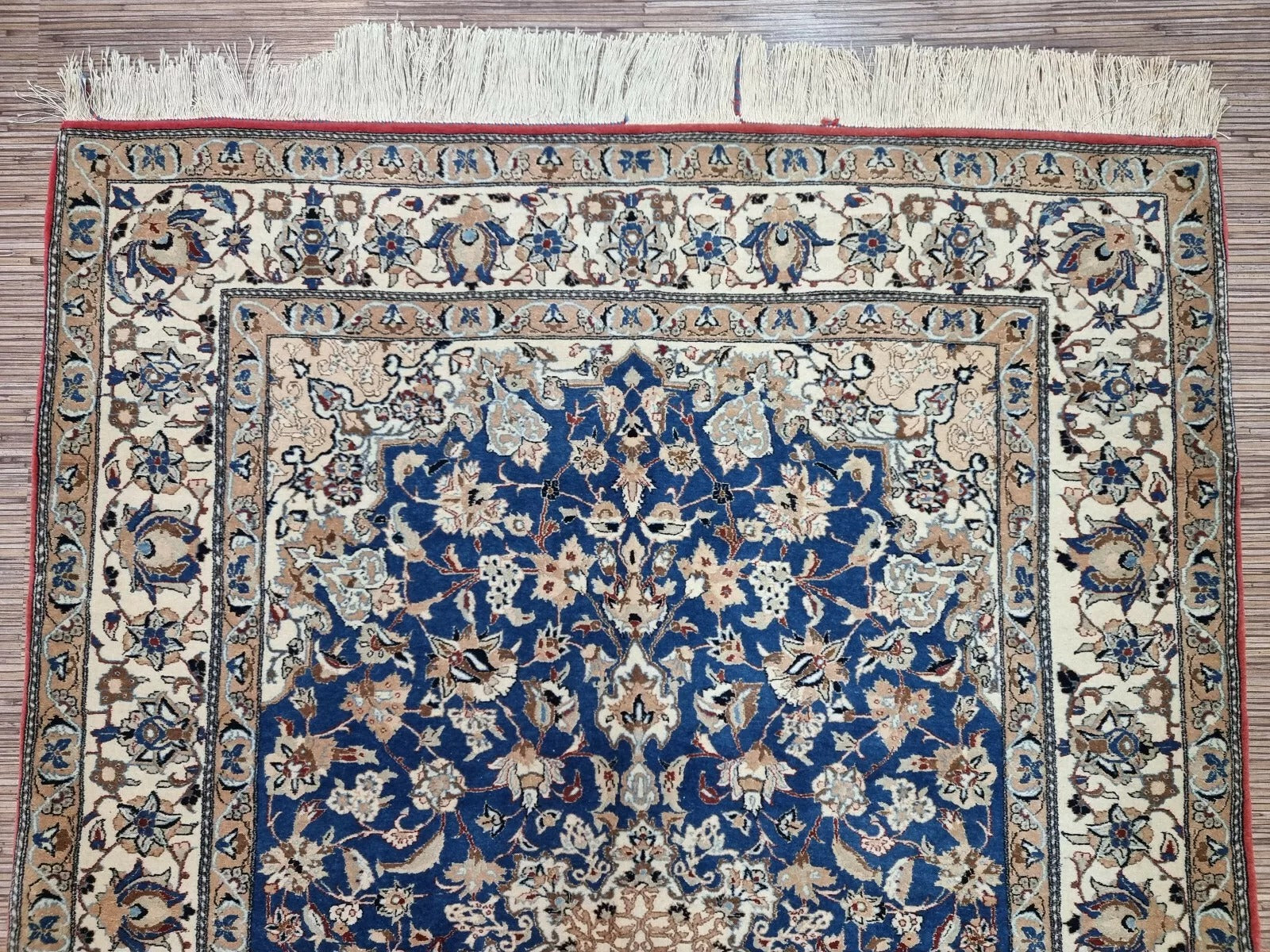 Full perspective of an antique Persian Nain rug displayed in a room setting, demonstrating its 3.9 × 5.4 foot size as a refined accent piece for traditional or modern interiors.

