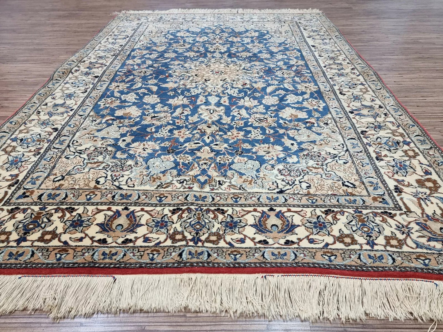 Collector-quality antique Persian Nain rug circa 1920s with an ivory field, navy blue medallion, floral corner spandrels, and a harmoniously patterned border system.

