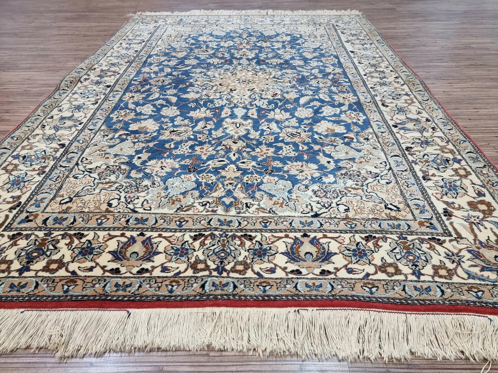 Collector-quality antique Persian Nain rug circa 1920s with an ivory field, navy blue medallion, floral corner spandrels, and a harmoniously patterned border system.

