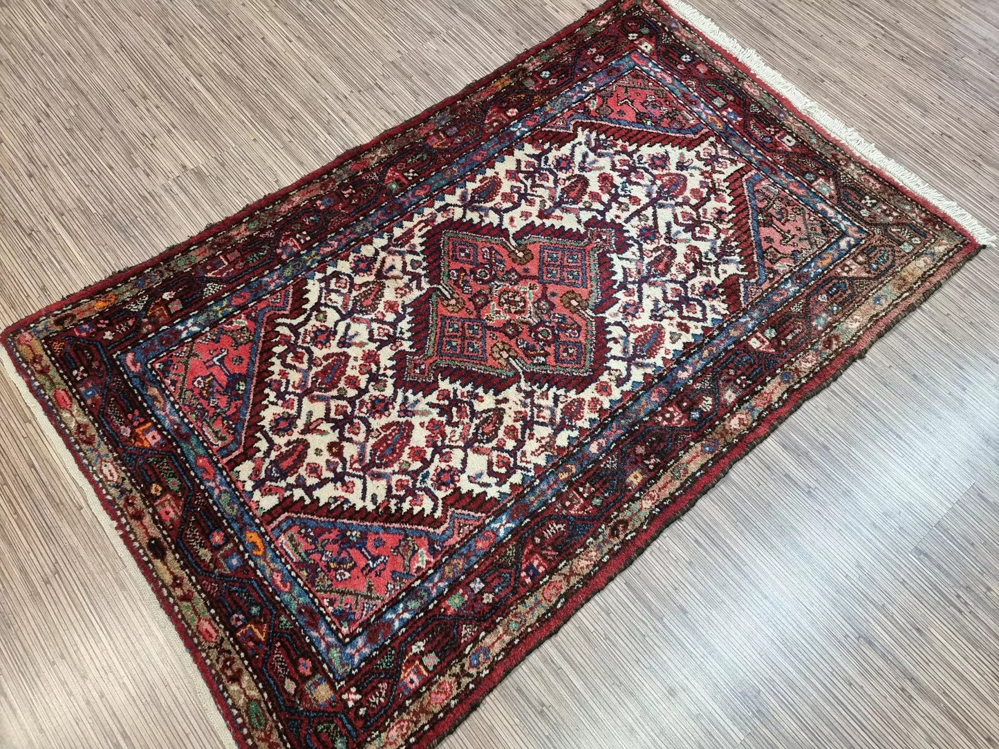 Full perspective of a vintage Persian Hamadan rug displayed in a room, demonstrating its 3.1 × 5.1 foot size as a charming accent piece for modern or traditional interiors.

