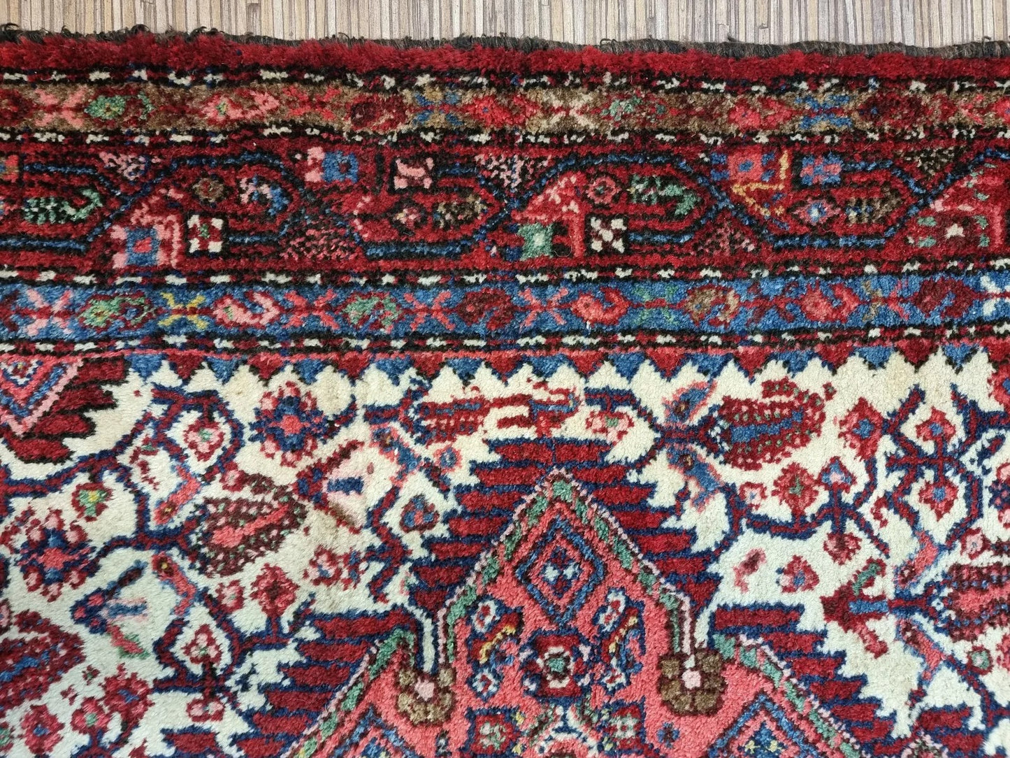 Full view of a vintage hand-knotted Persian Hamadan rug laid flat, showing its rectangular shape, multiple borders, and classic all-over floral pattern with a central medallion.

