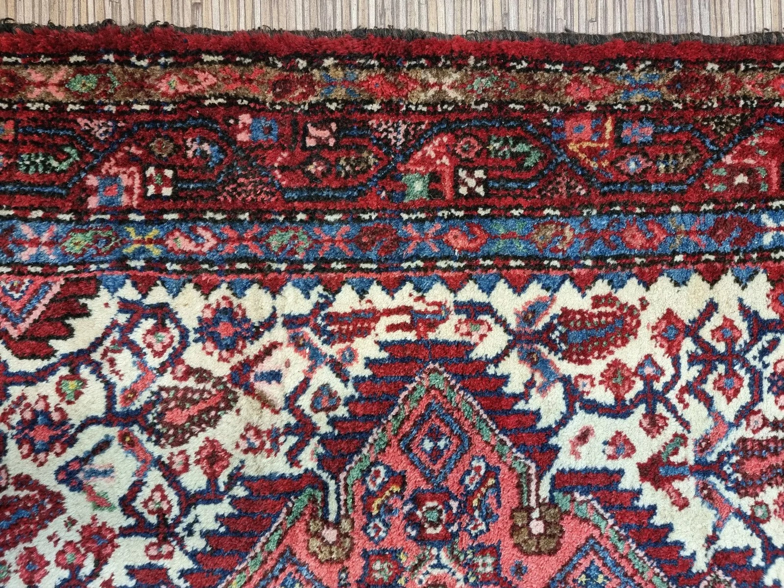 Full view of a vintage hand-knotted Persian Hamadan rug laid flat, showing its rectangular shape, multiple borders, and classic all-over floral pattern with a central medallion.

