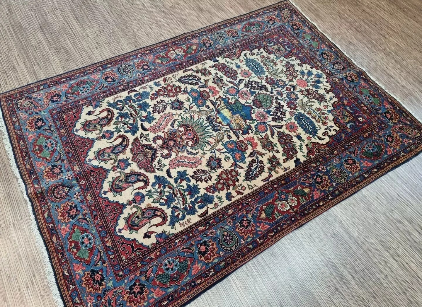 Detail of the central medallion on a vintage Persian Kashan rug, showcasing intricate floral motifs and delicate arabesques typical of Kashan's weaving heritage, with soft beige and subtle highlight coloration.

