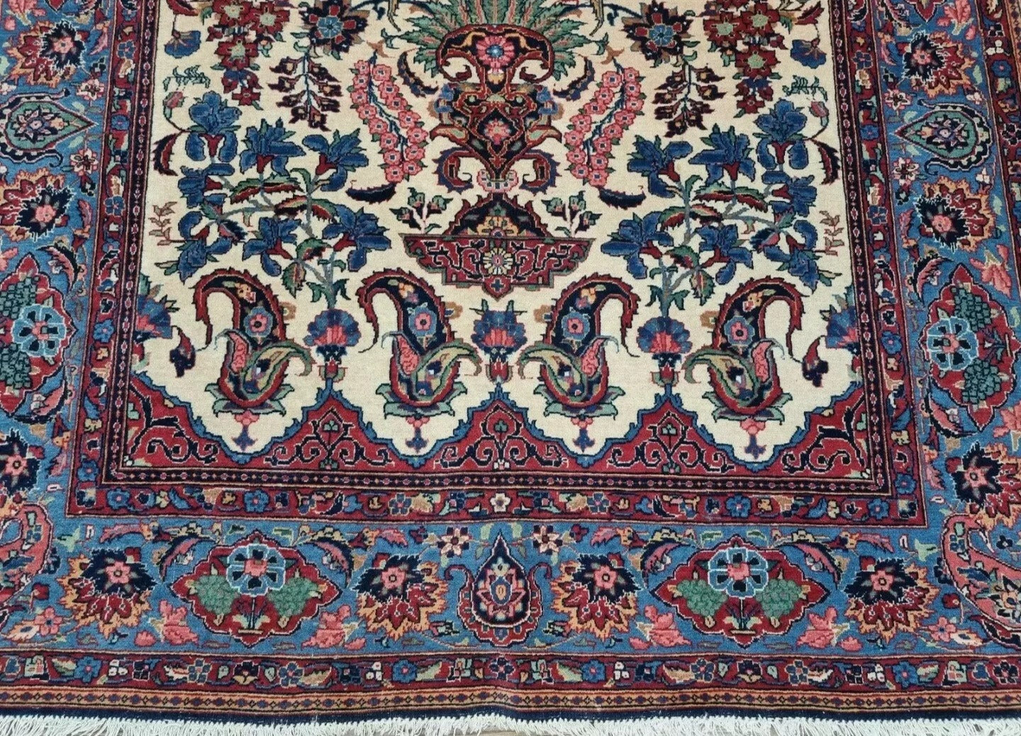 Full perspective of an antique Persian Kashan rug displayed in a room, demonstrating its 4.5 × 6.4 foot size as an elegant centerpiece for traditional interiors.

