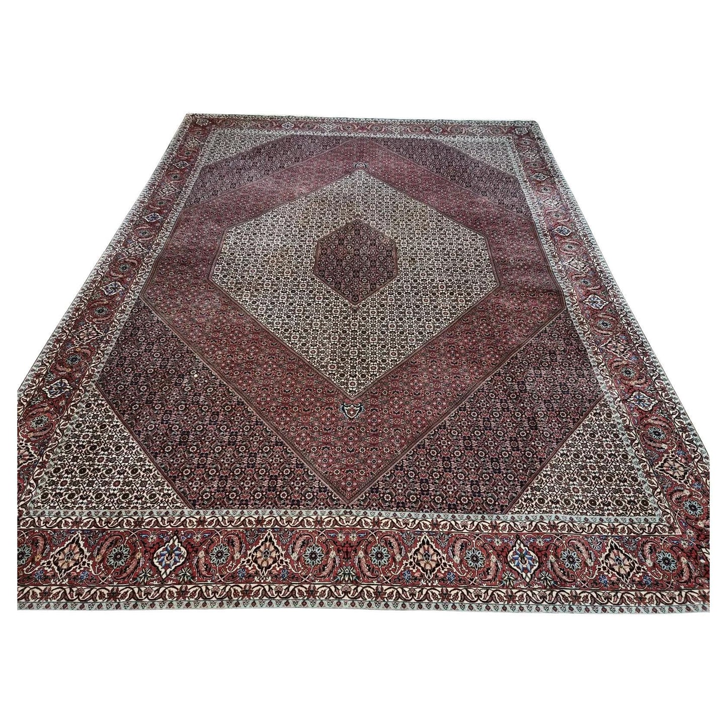 Full view of a handmade vintage Persian Bidjar rug from the 1970s, featuring a rich red field with an elaborate central medallion and intricate floral patterns, hand-knotted in wool on a cotton foundation – known as "the iron rug of Persia" for its exceptional durability.

