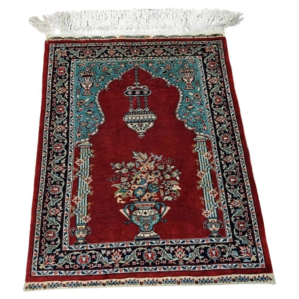 Full view of a handmade vintage Turkish Hereke silk rug from the 1970s, featuring a rich red base with intricate traditional motifs, hand-knotted entirely in 100% pure silk with an exceptional knot density of 13×13 knots/cm², signed by the artisan.

