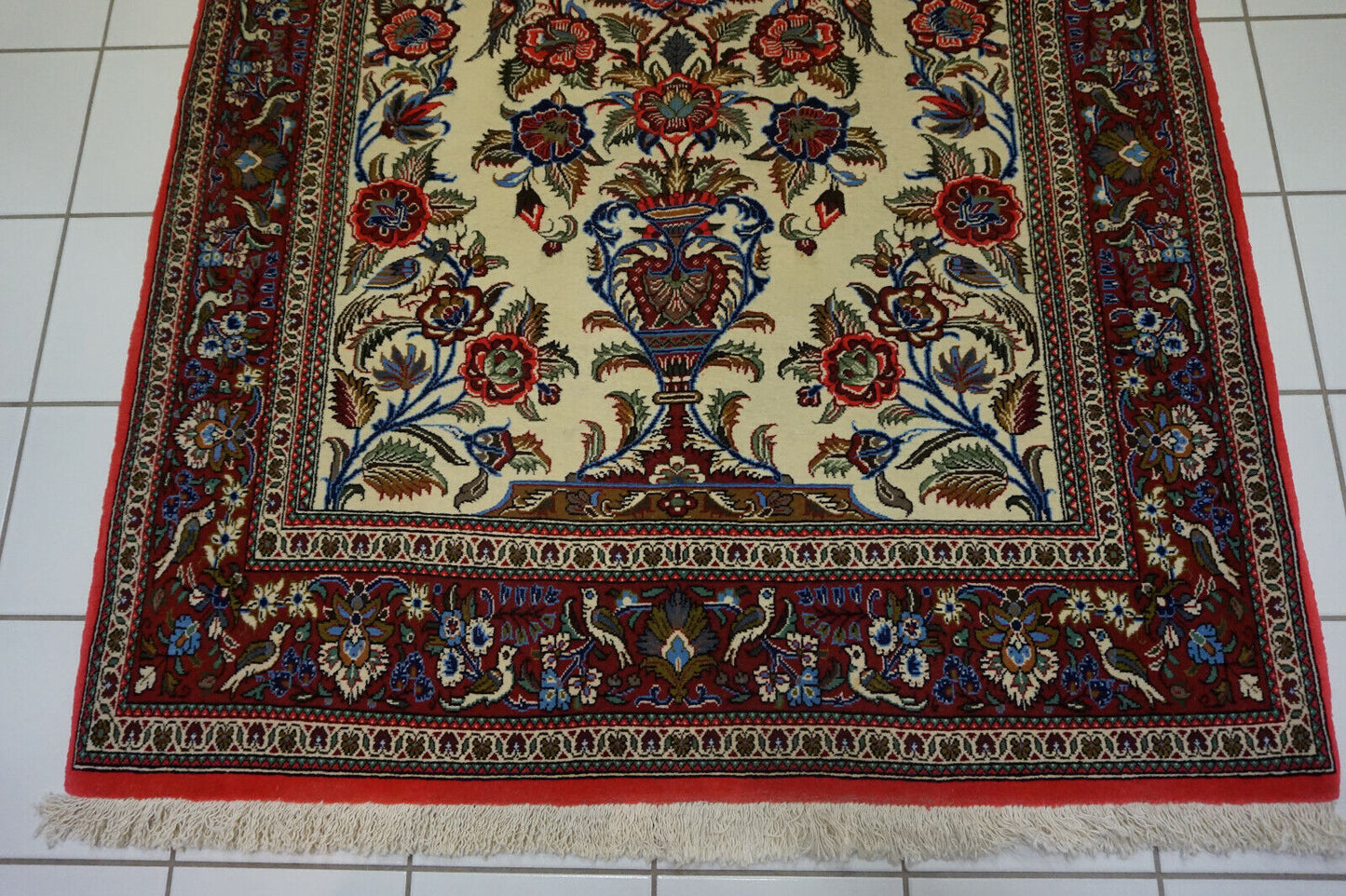 Intricate bird motifs symbolizing freedom on the Rug border