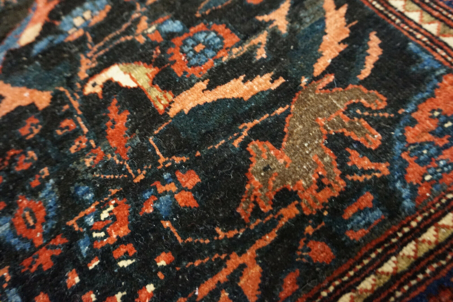 Close-up of the intricate animal motifs on the Handmade Antique Persian Tehran Rug