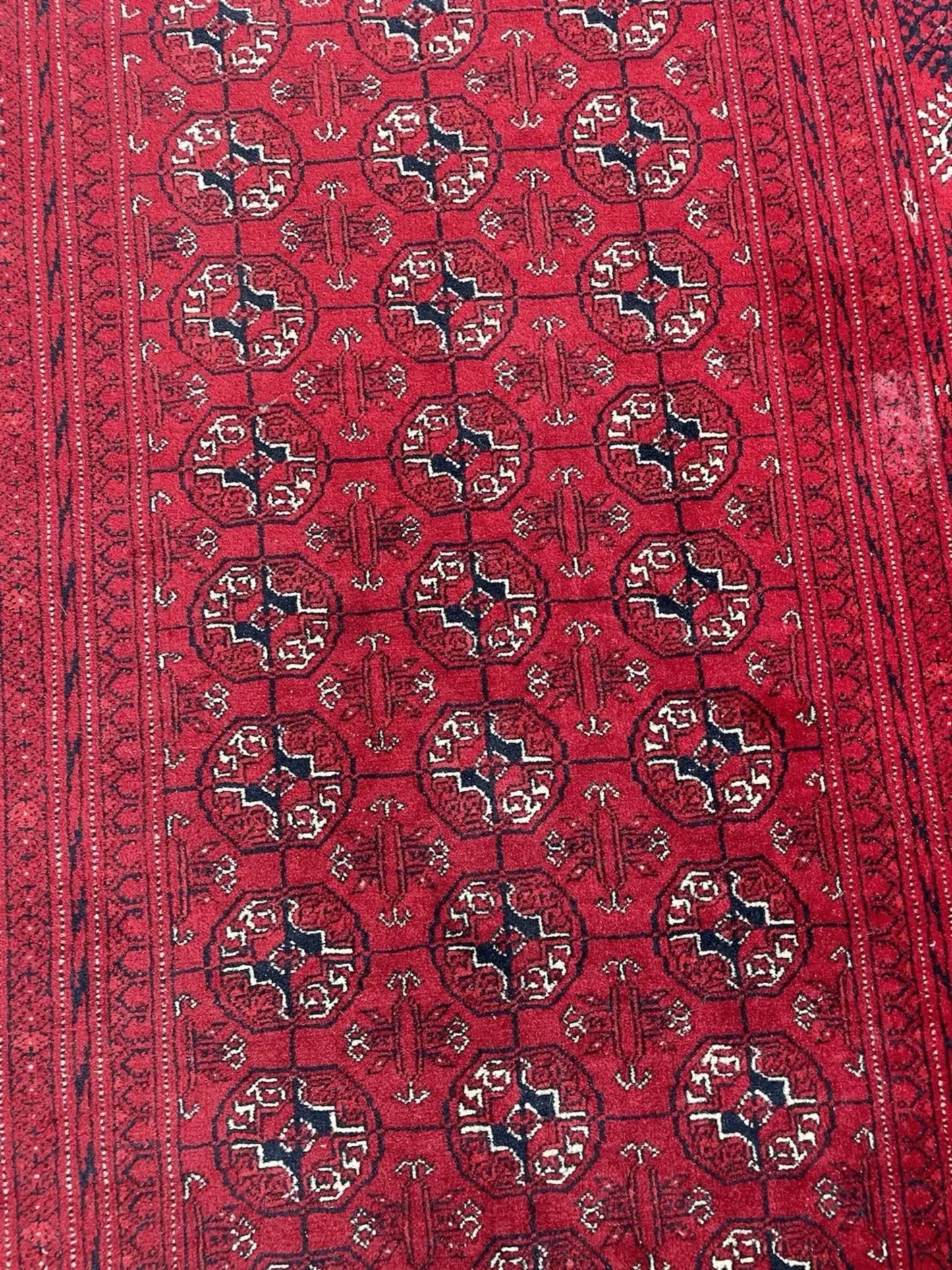 Column of tribal medallions on deep red field

