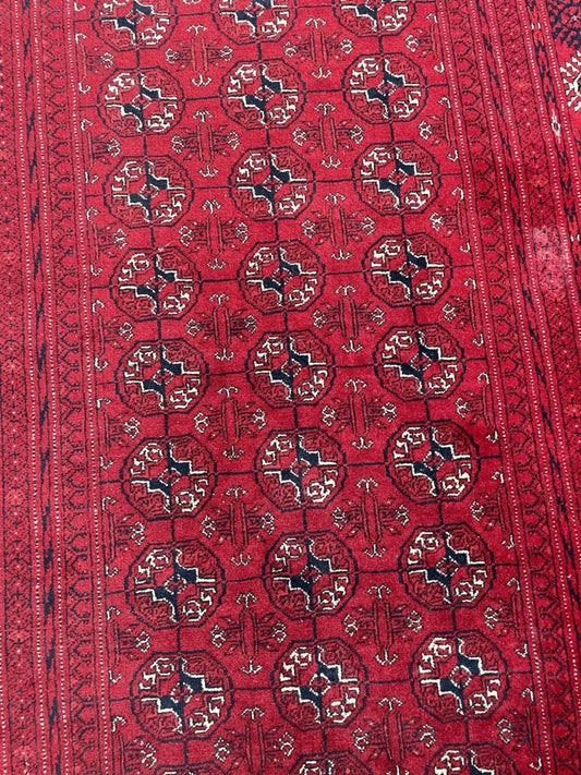 Column of tribal medallions on deep red field

