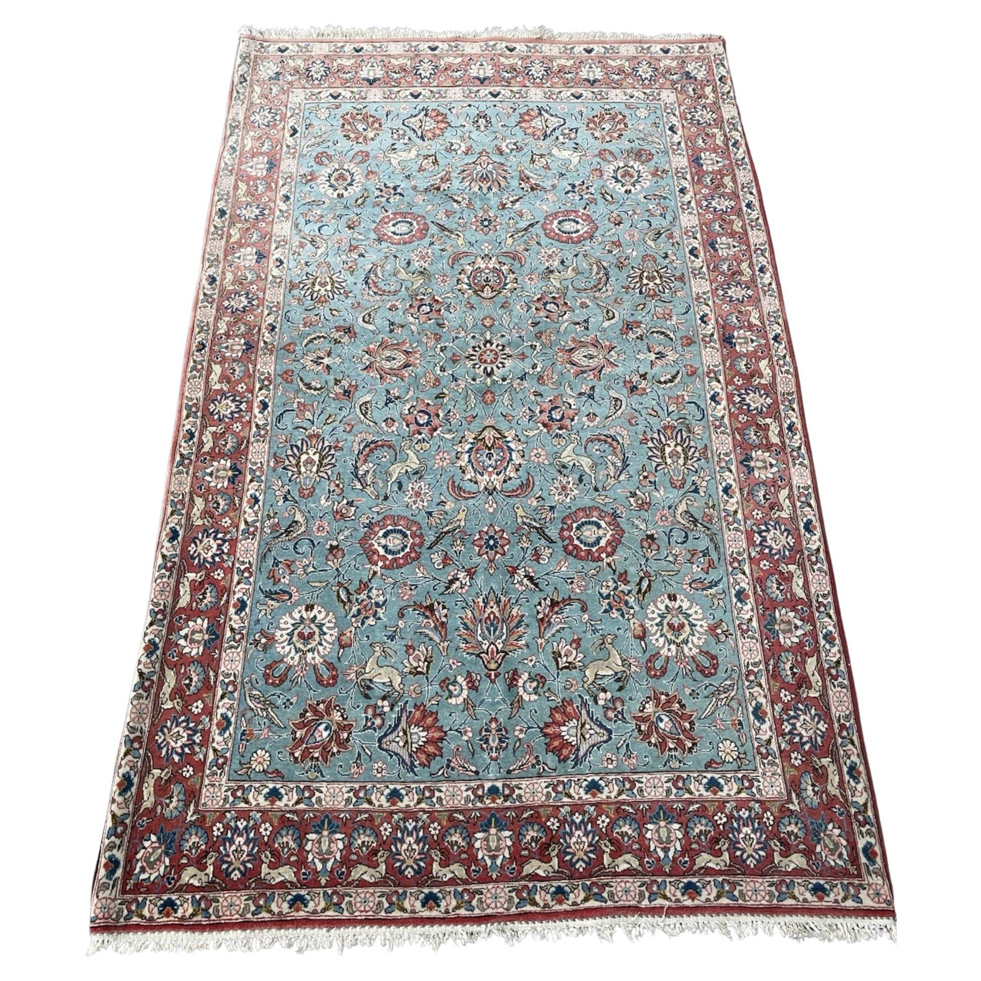 Antique Kazvin rug with floral and animal motifs on aqua field


