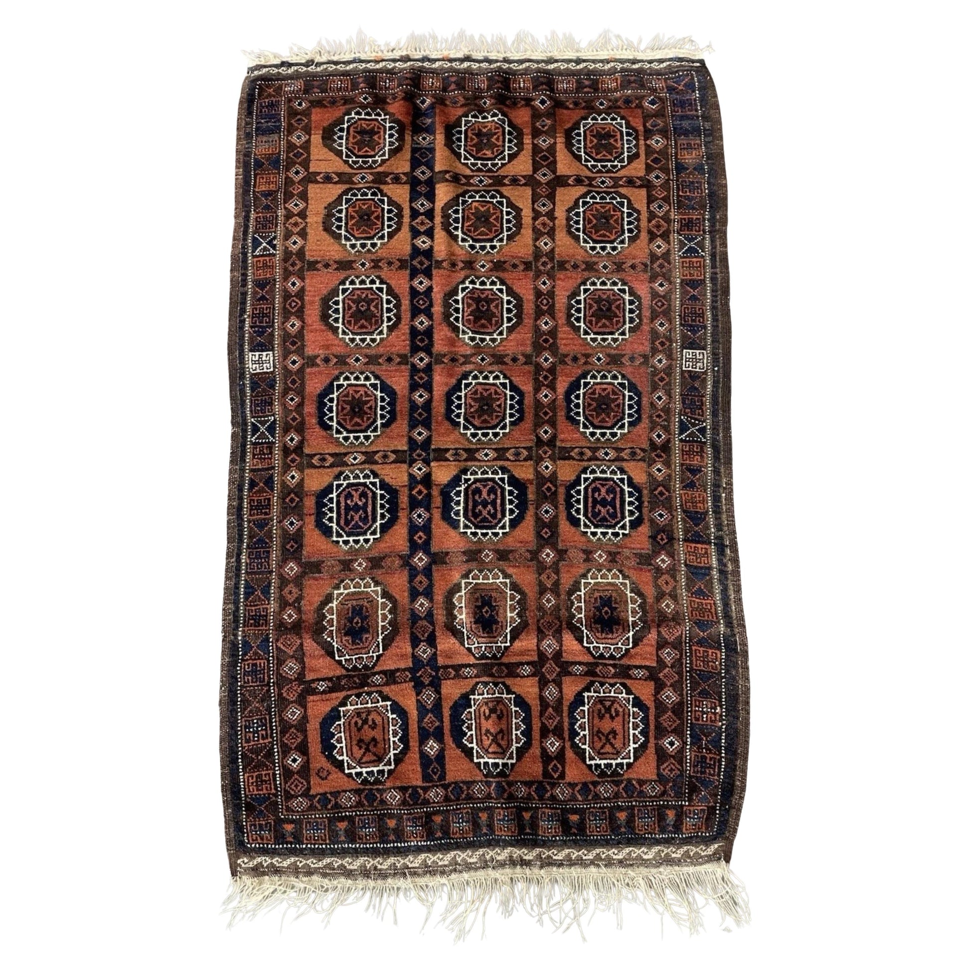 Full front view of the antique Afghan Baluch rug showing its full geometric design.

