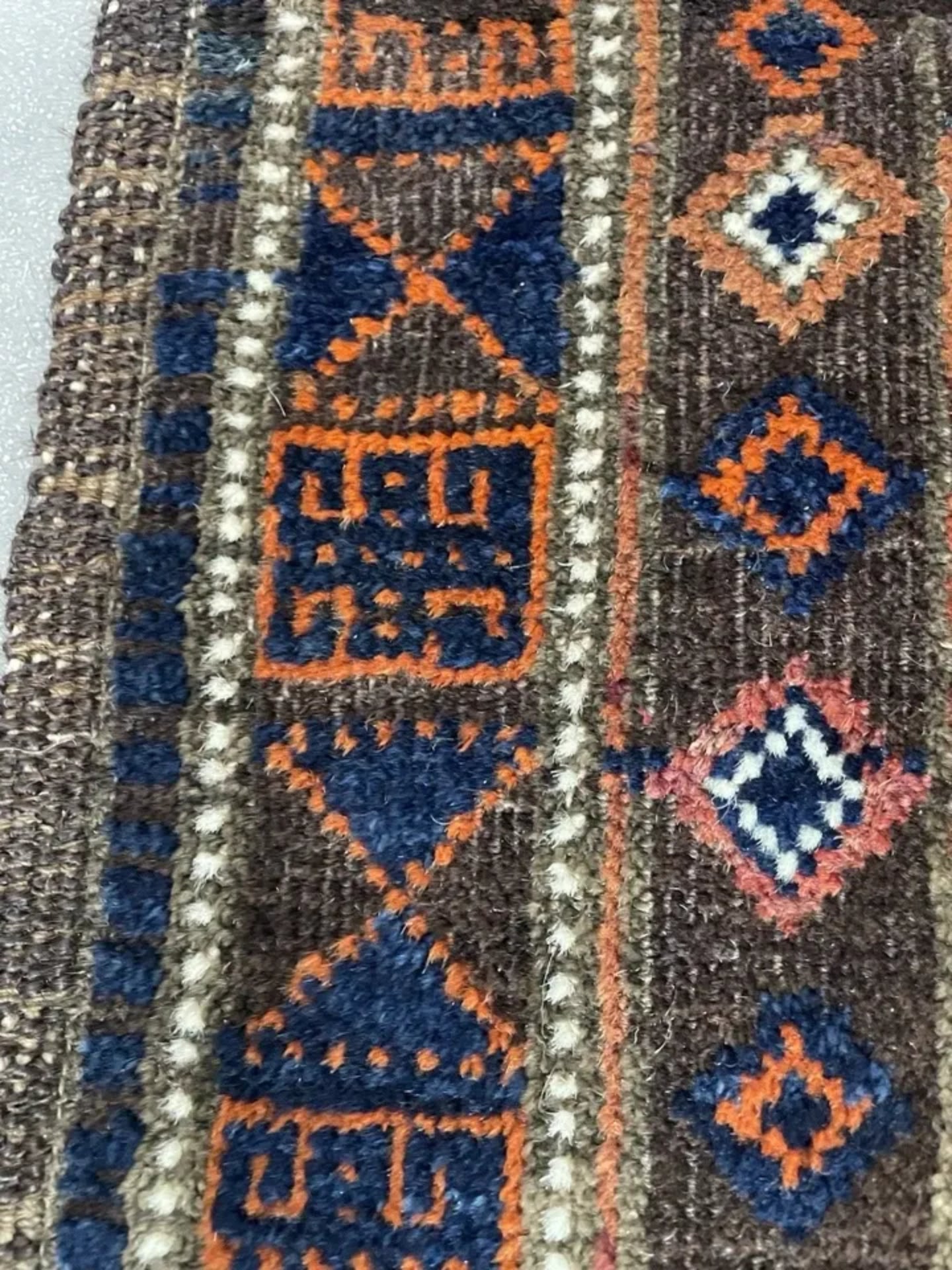 Macro shot of the interlocking geometric medallions and navy blue motifs.

