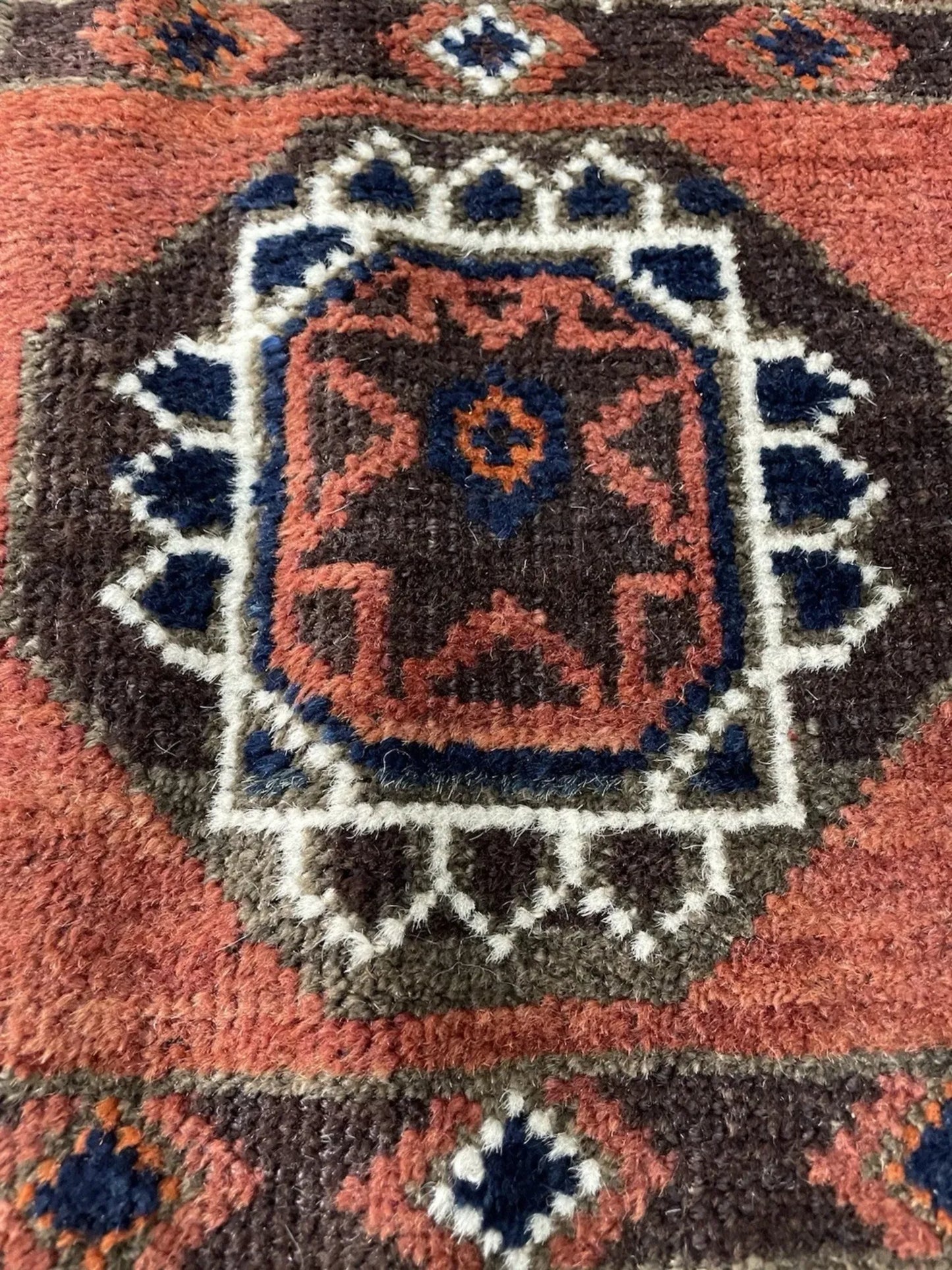 Side angle view showing the rug's dense hand-knotted pile and edges.

