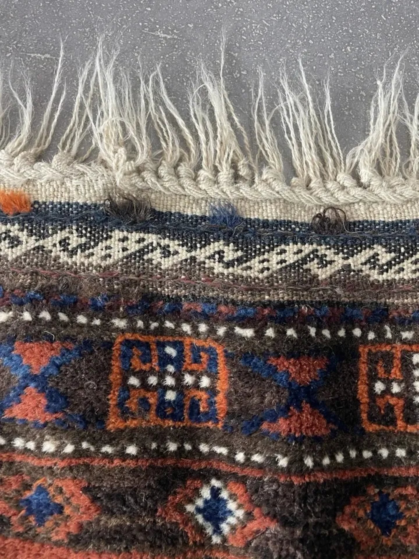 Close-up capturing the rich color palette of terracotta, navy, and cream.

