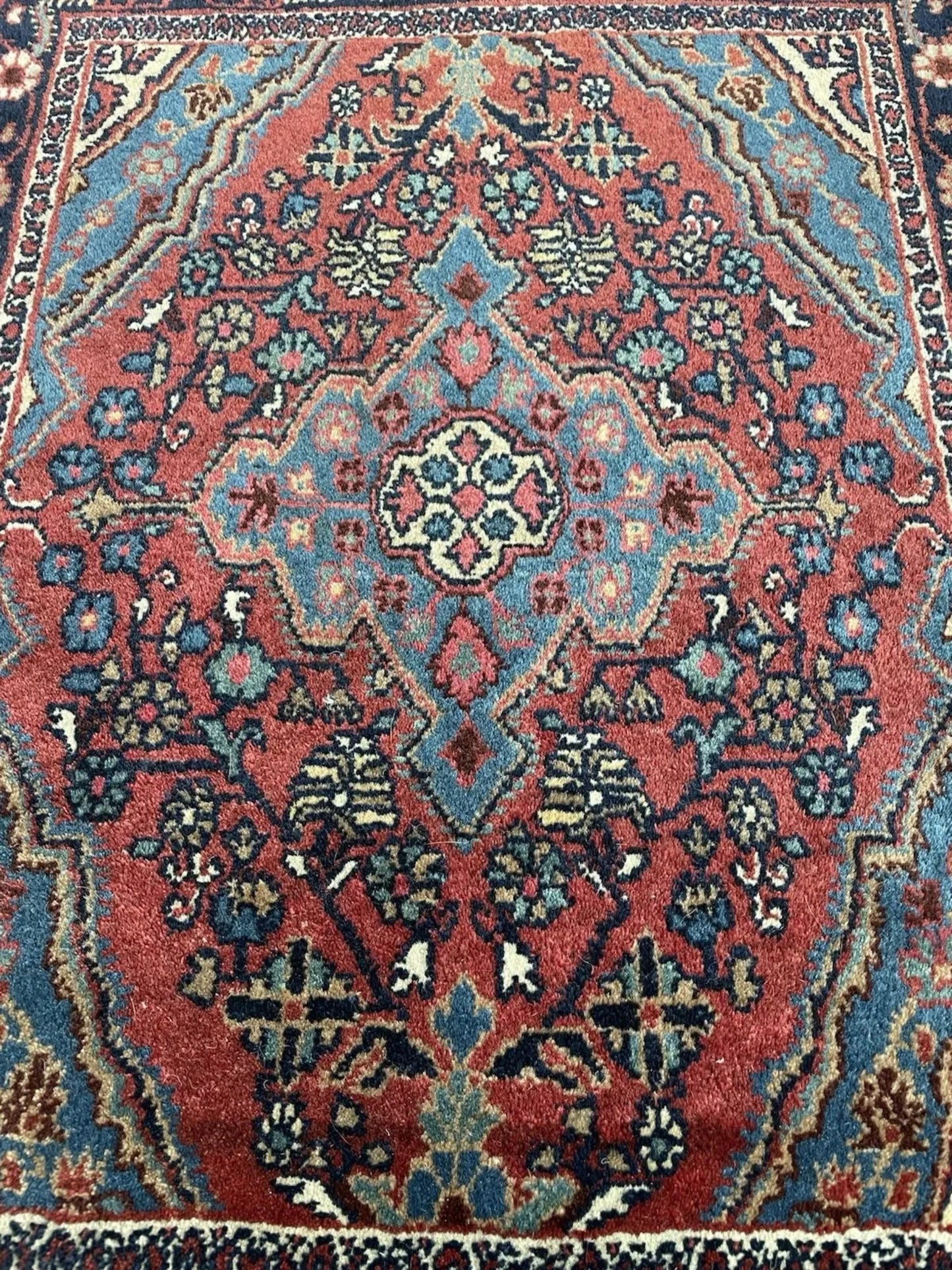 Detail of the rug's dark border and edge finishing on the short side.

