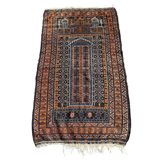 Full front view of the antique Baluch prayer rug showing the Mihrab arch.

