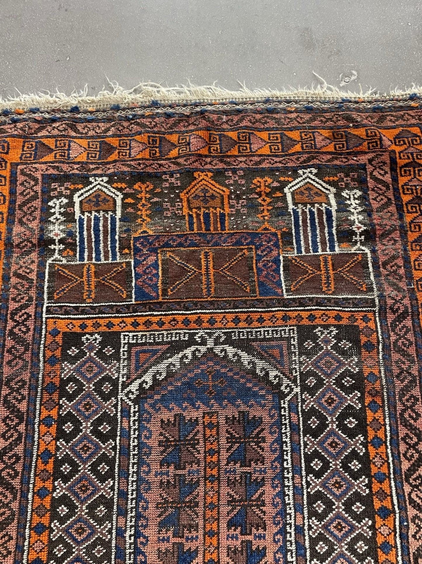 Close-up of the fringe and one end of the antique Baluch rug.

