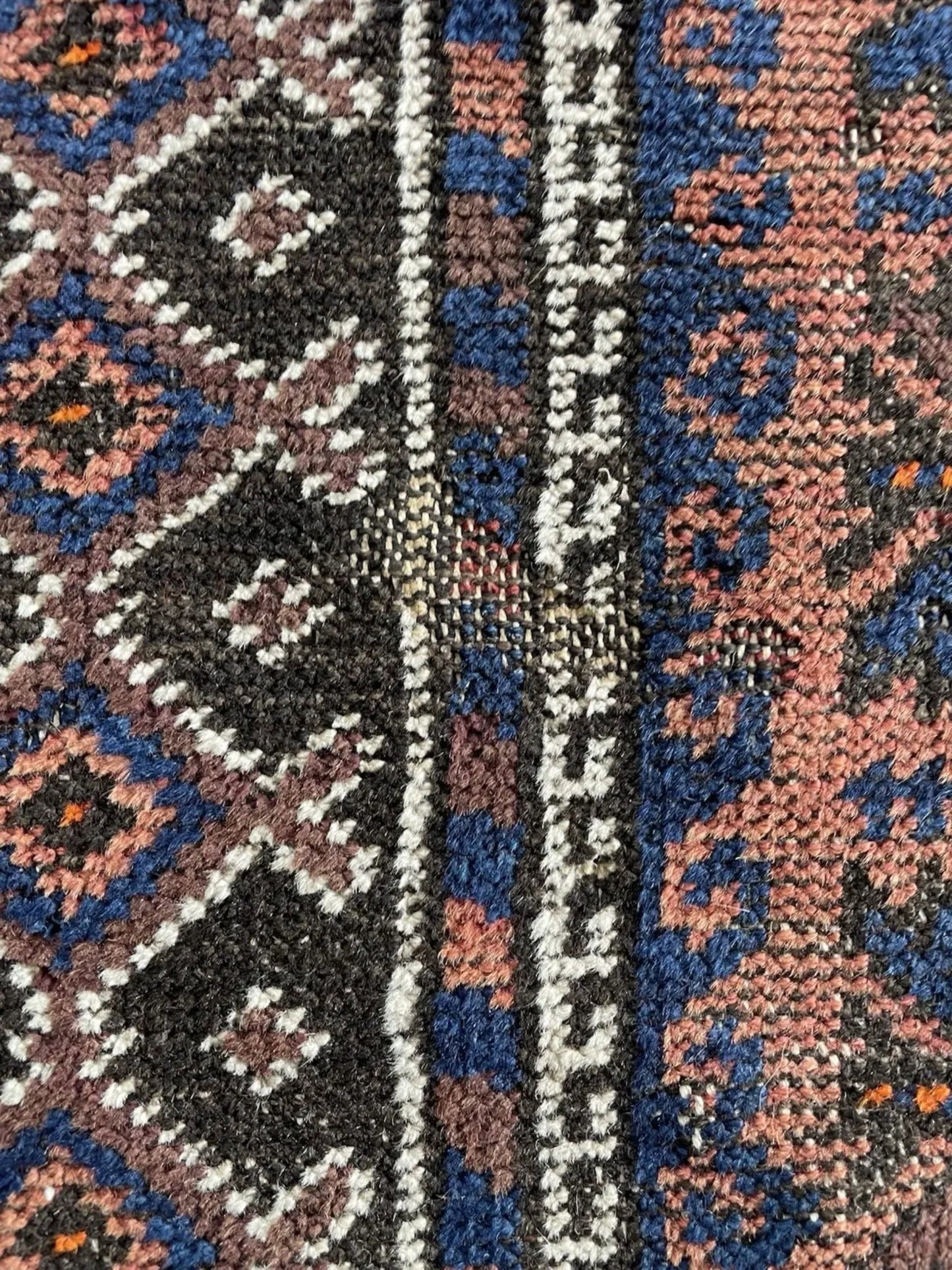 The prayer rug displayed to highlight its symmetrical sacred design.

