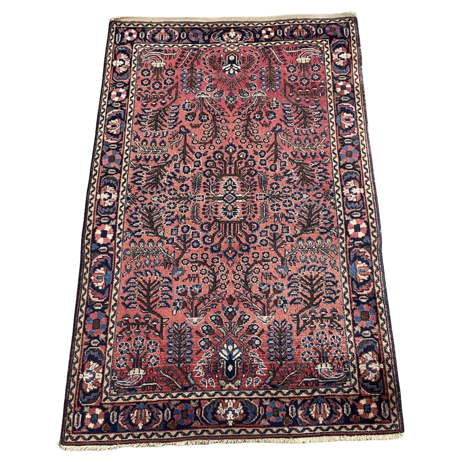 Full front view of the antique Persian Sarouk rug showing the overall floral design.

