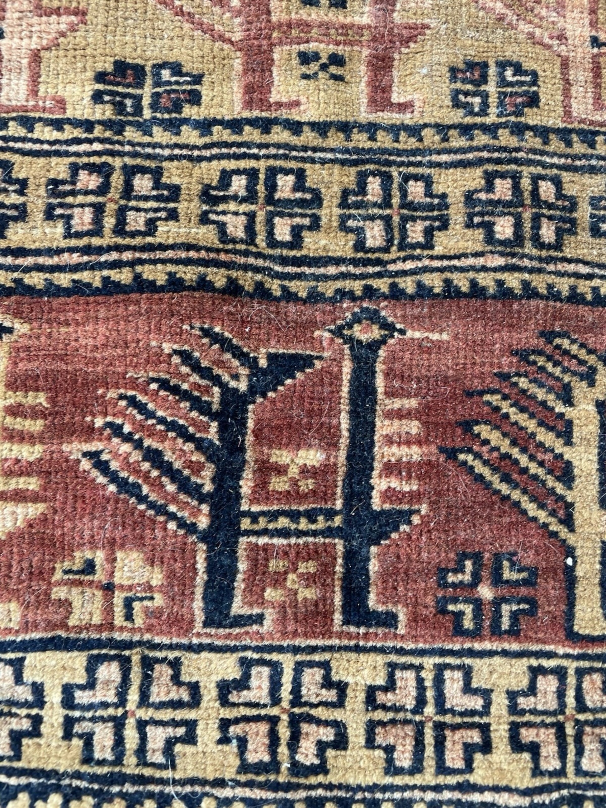 Close-up detail of the interconnected tribal motifs on the terracotta field.

