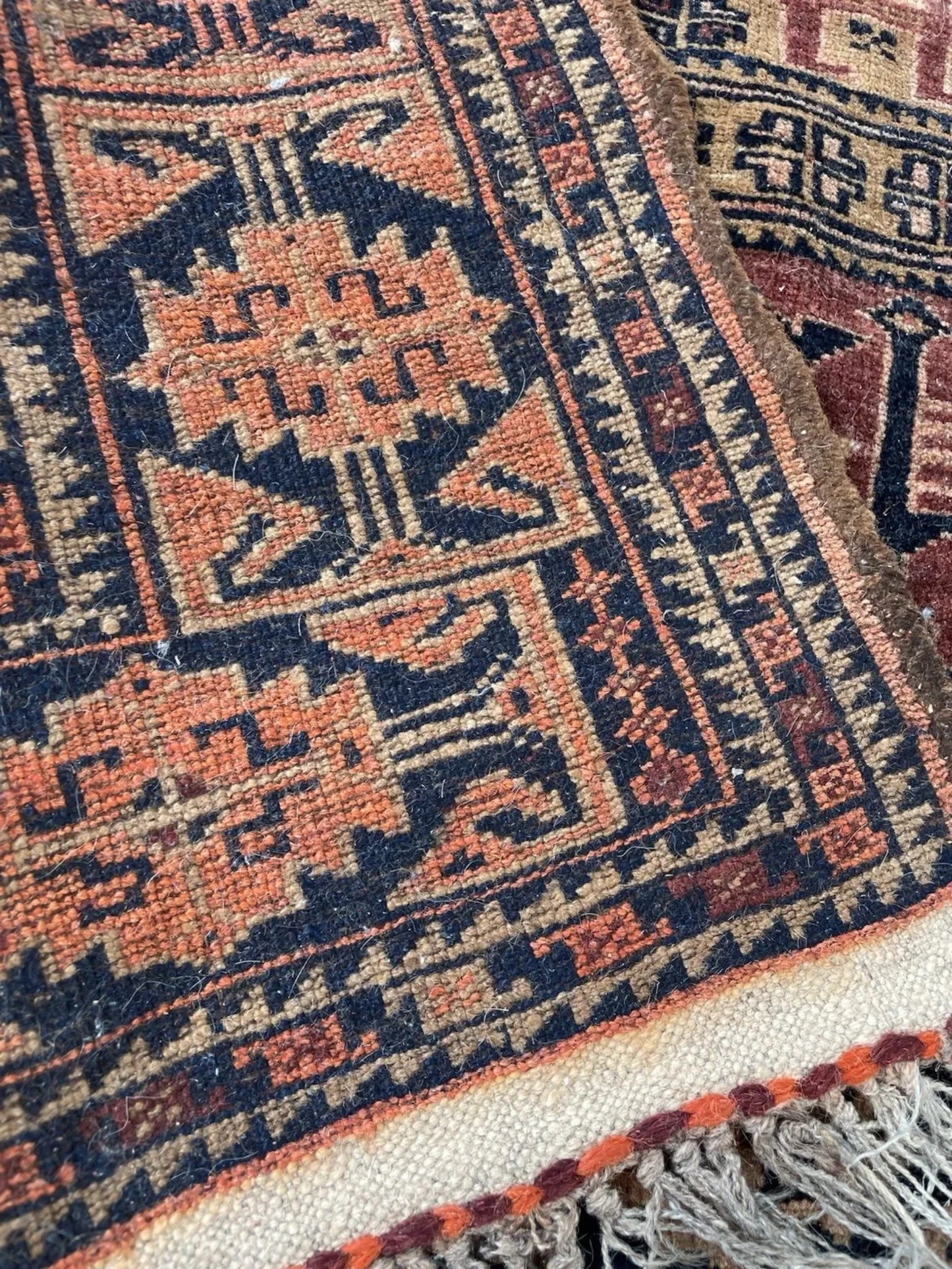 Detail view of Afghan Baluch rug pile showing high-quality wool texture and natural dye colors from the 1920s