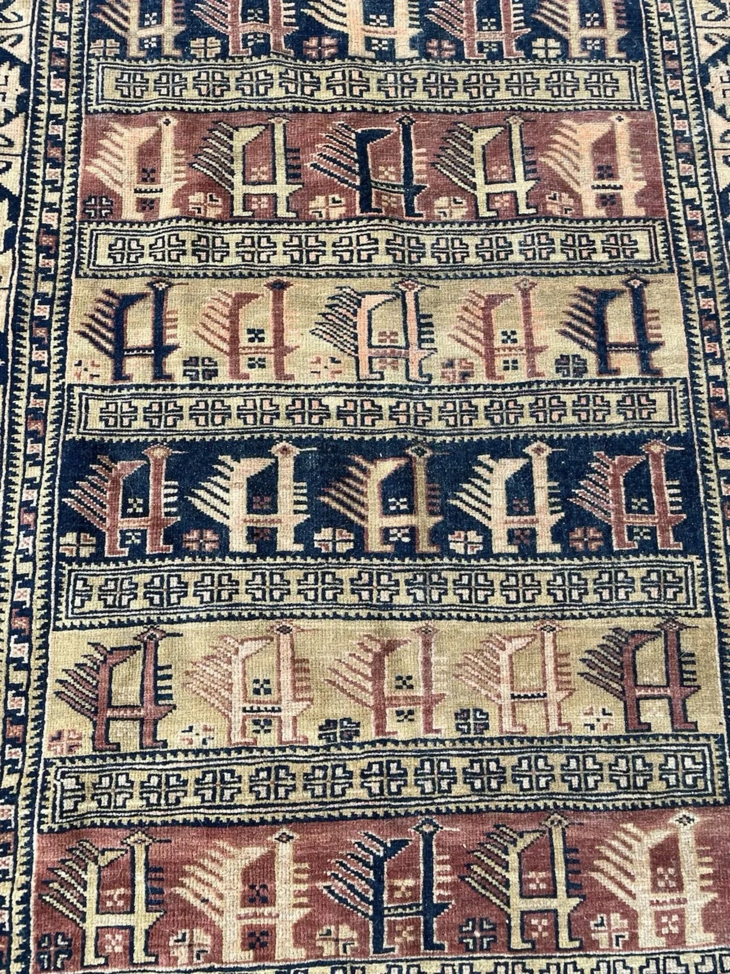 Full front view of the antique Baluch rug showing its all-over geometric design.

