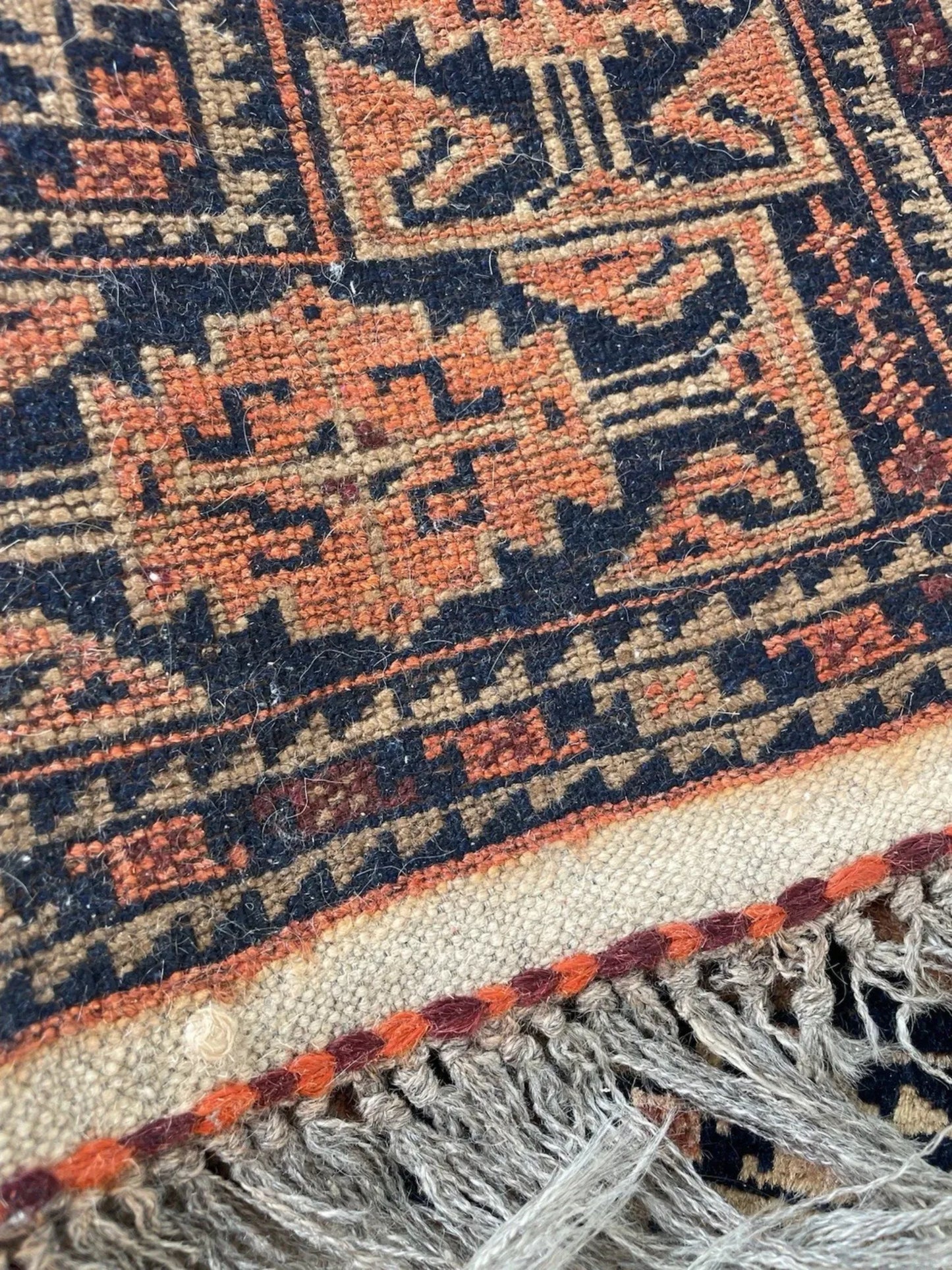 Shot focusing on the aged patina and soft, low pile of the antique wool.

