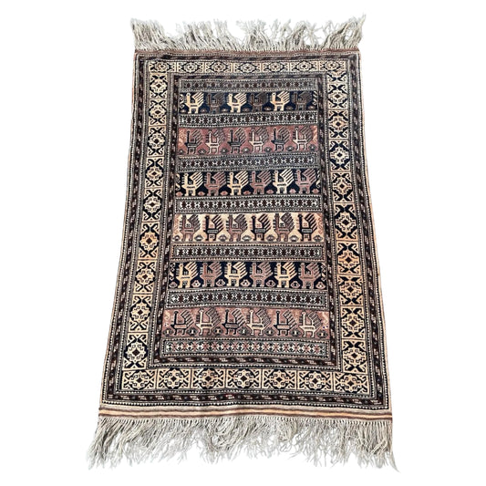 Full front view of the antique Baluch rug displaying its geometric pattern.

