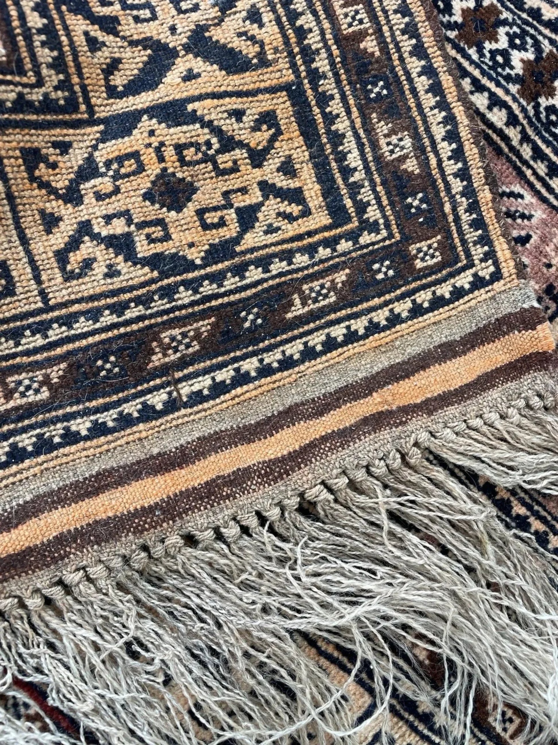 Shot focusing on the soft, aged patina of the antique wool pile.

