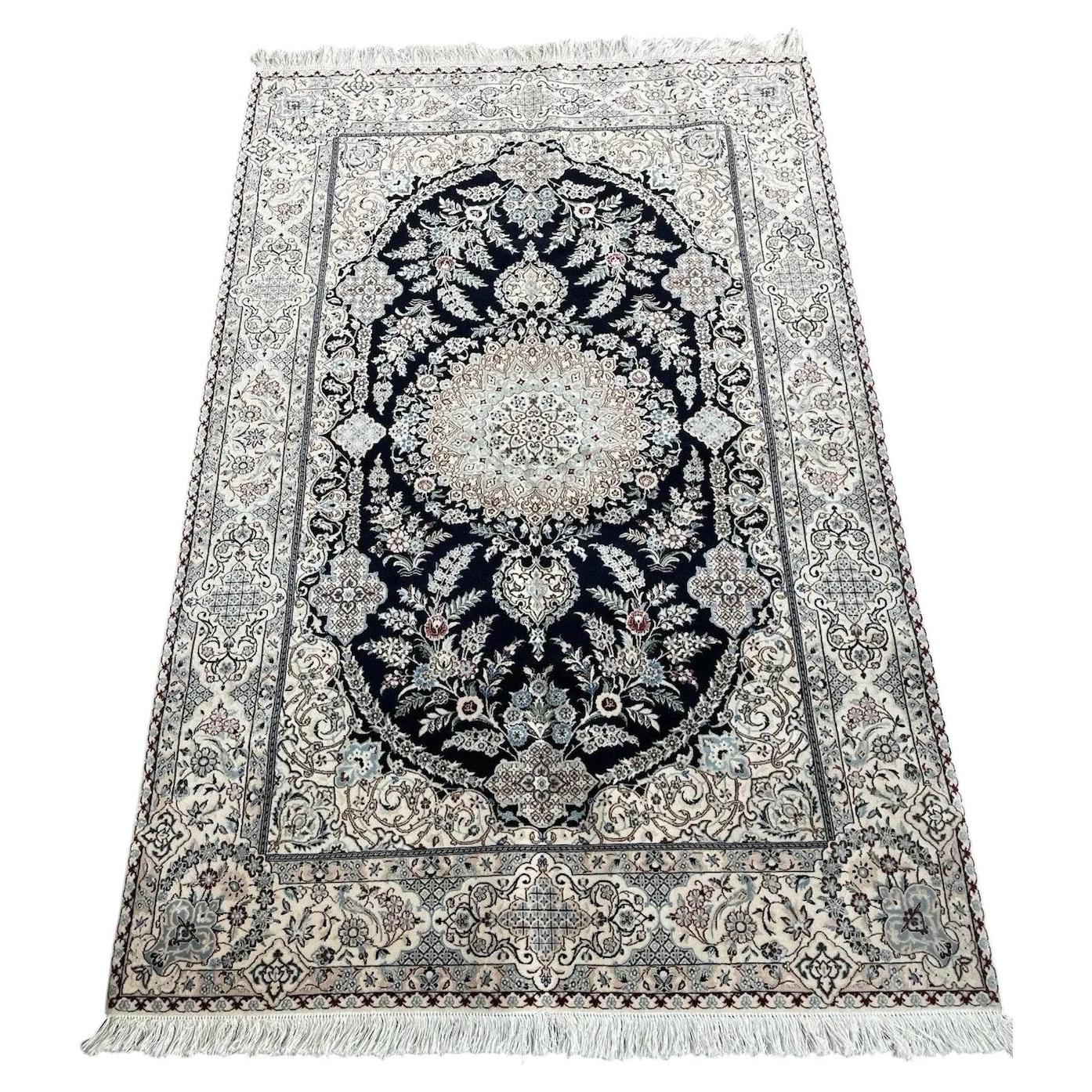 Handmade vintage Persian Nain wool rug from the 1960s featuring intricate floral medallion design on navy blue field.

