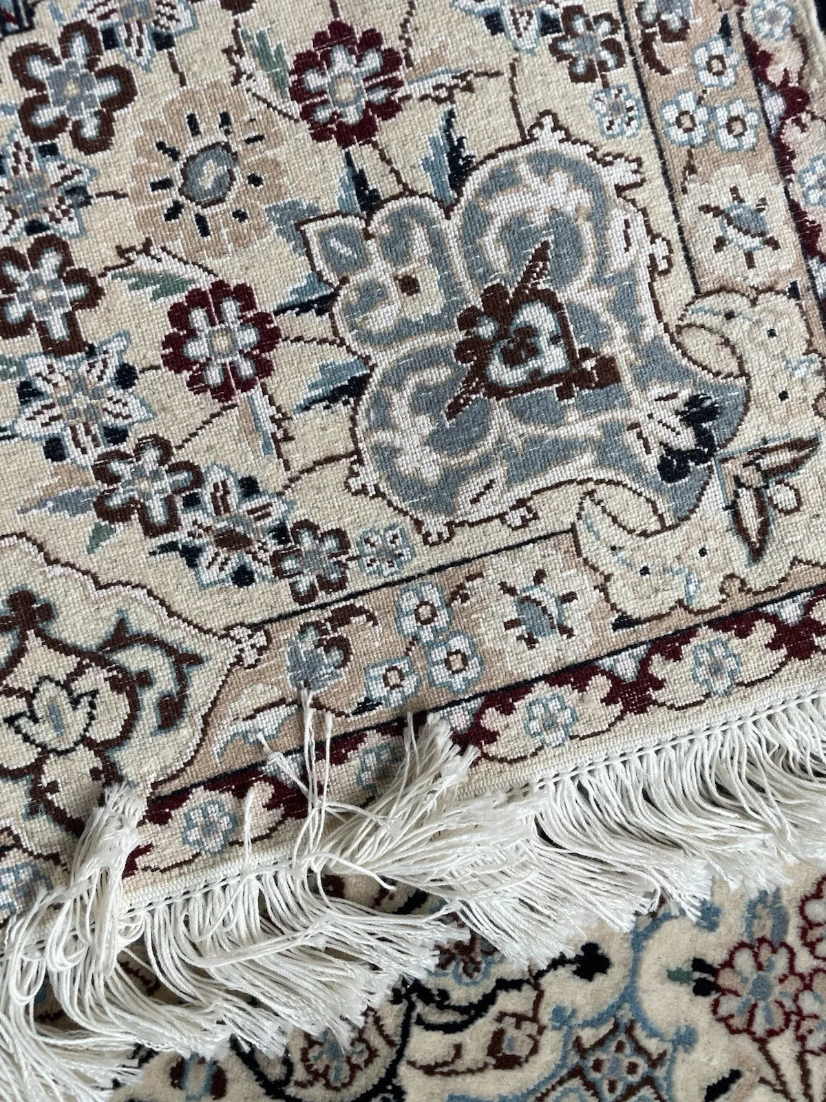 Traditional Persian Nain rug pattern featuring a central medallion, corner spandrels, and repeating vine scrolls.

