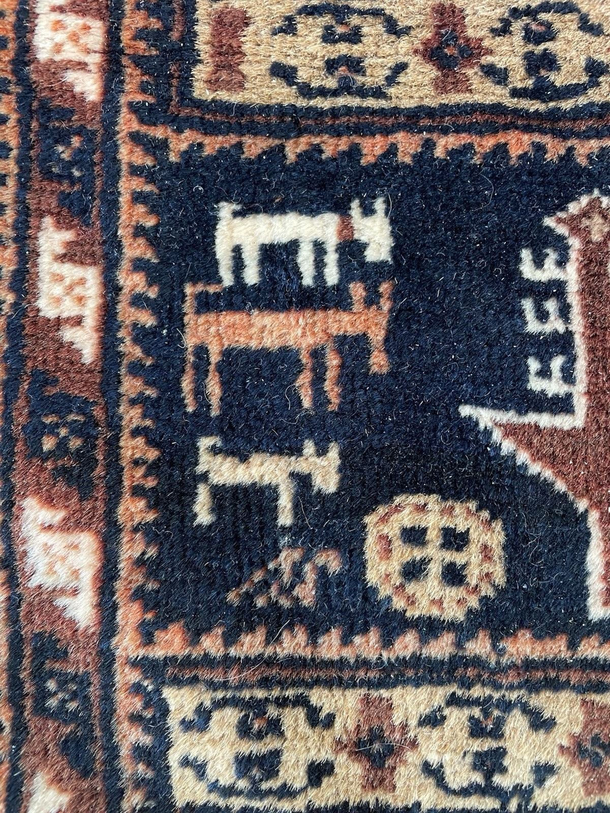 Warm, grounded color palette of browns, tan, off-white, and indigo on this 1920s Afghan Baluch rug with a soft, durable low pile.

