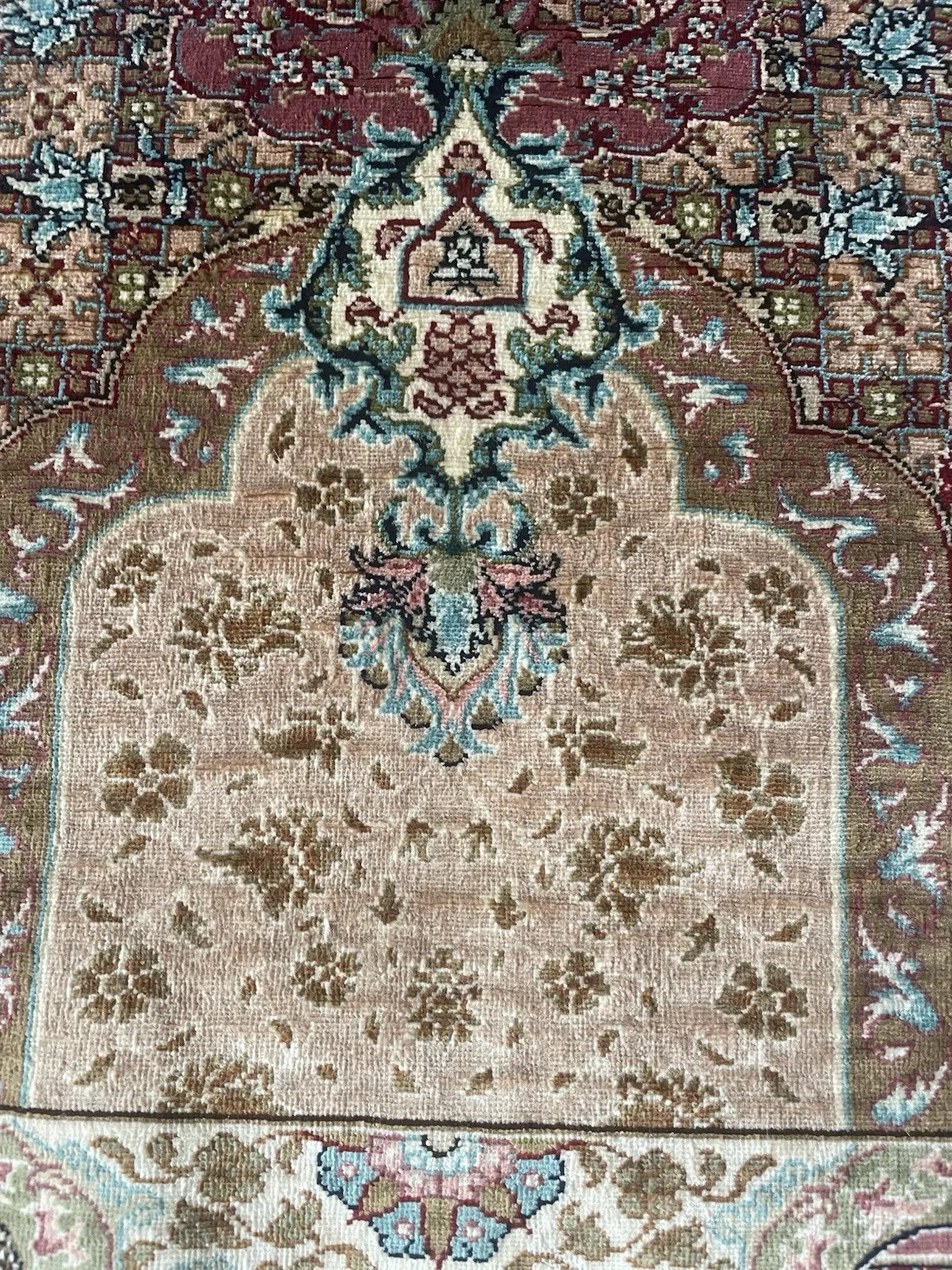 Ornate vintage Hereke silk rug from Turkey, highlighting its extra fine weave and collectible signature woven into the design.

