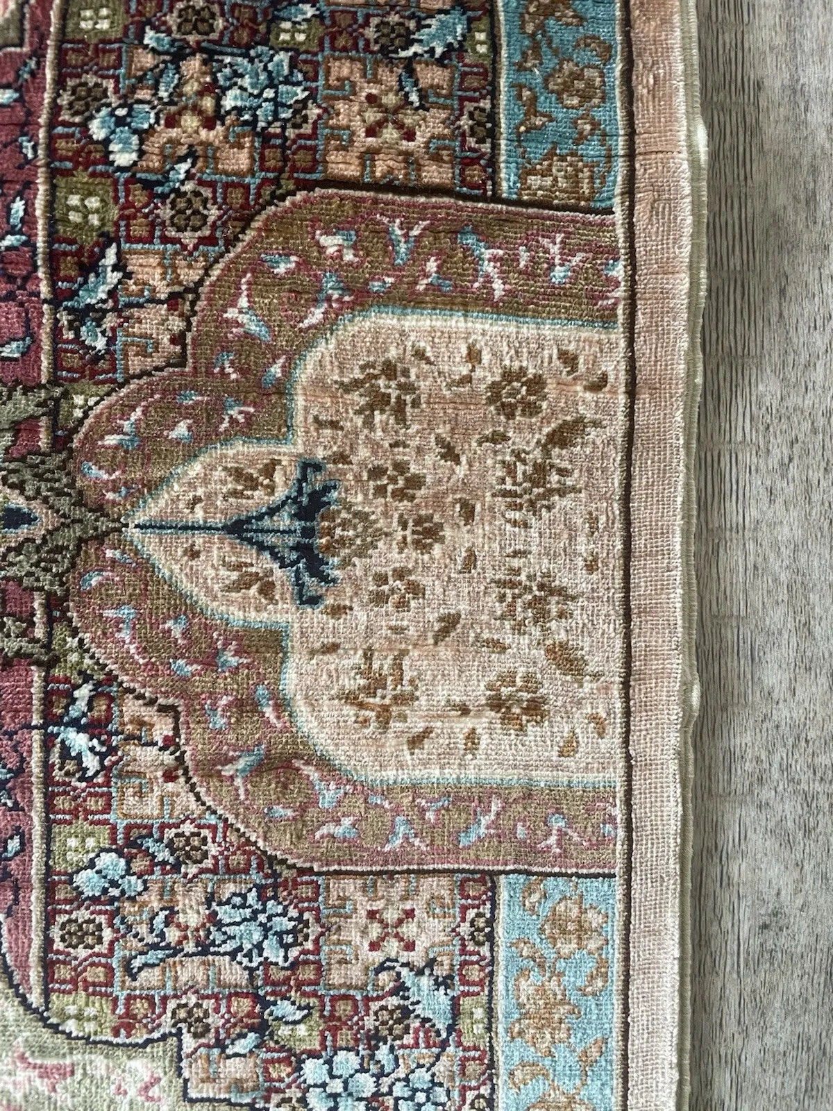 Decorative statement piece: handmade Turkish Hereke silk rug with ivory field, rose accents, and intricate Ottoman-inspired floral details.

