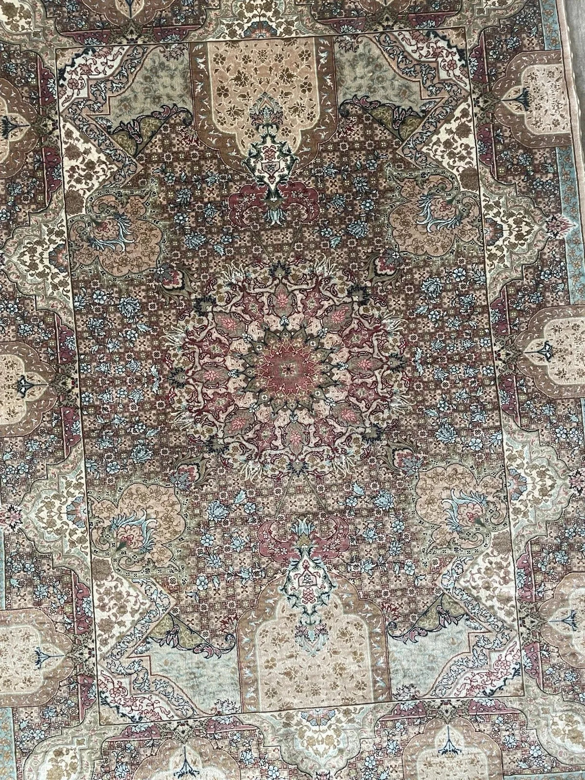Vintage 1970s Hereke silk rug on a light background, demonstrating ultra-fine knot density and traditional corner spandrel designs.

